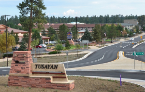 Entry way roundabout into Tusayan with town sign in the foreground.