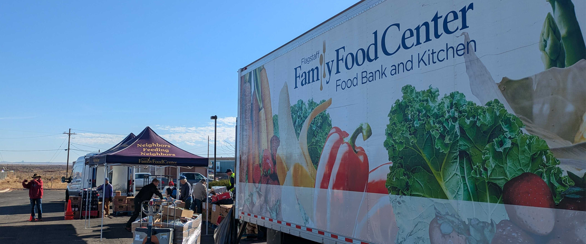 Image of the Family Food Center truck in a parking lot and volunteers distributing the food to people in cars