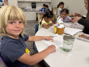 Student working at a table during a KinderCamp class in Flagstaff.